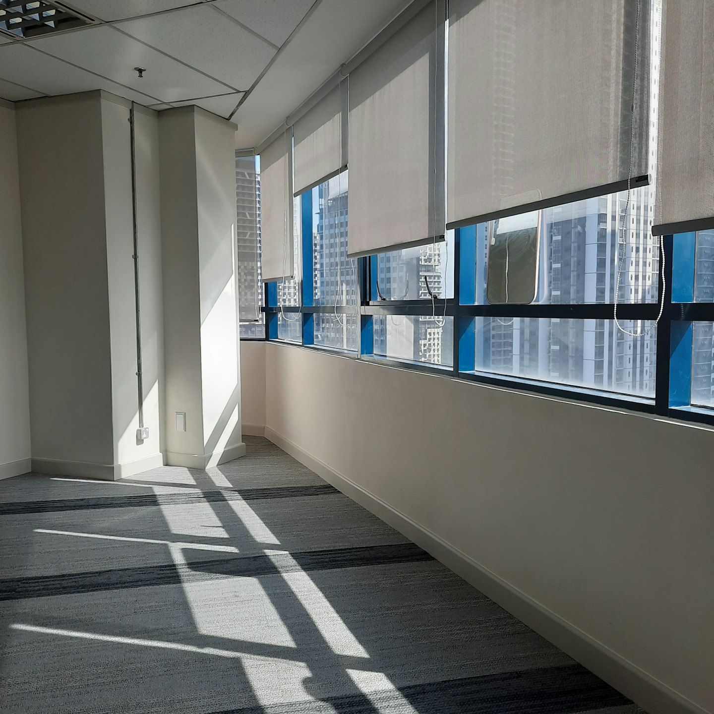 Empty modern office with windows overlooking a city skyline.